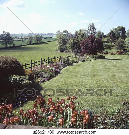 Stock Image - Lawn in summer country garden. Fotosearch