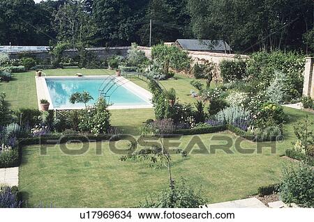 Lawn with formal flowerbeds and swimming pool in large country garden in summer View Large Photo Image Picture - Lawn with formal flowerbeds and swimming pool in large country garden in summer. Fotosearch