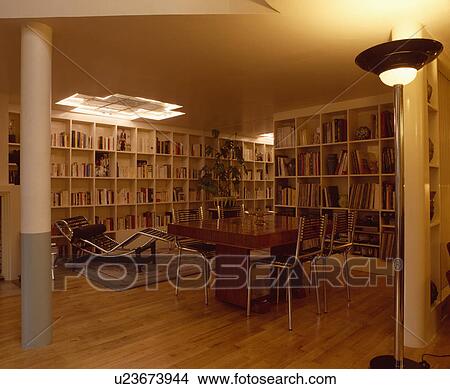 Le Corbusier chaiselongue and uplighter in twenties style dining room with parquet floors and shelving on walls  View Large Photo Image Picture - Le Corbusier chaiselongue and uplighter in twenties style dining room with parquet floors and shelving on walls . Fotosearch