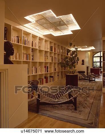 Le Corbusier chrome chaiselongue in modern living room with wall of shelving View Large Photo Image Stock Image - Le Corbusier chrome chaiselongue in modern living room with wall of shelving. Fotosearch