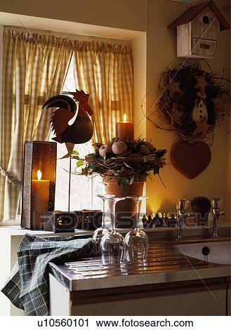 Stock Image - Lighted candles and ornaments on window sill. Fotosearch
