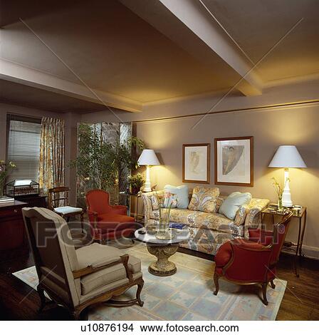 Lighted lamps in beige traditional town living room View Large Photo Image Picture - Lighted lamps in beige traditional town living room. Fotosearch