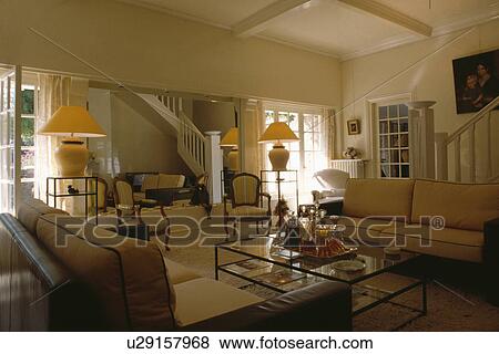 Lighted lamps in traditional cream country living room View Large Photo Image Stock Photo - Lighted lamps in traditional cream country living room. Fotosearch