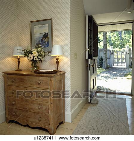 Lighted lamps on old chest of drawers hall with wallpaper and open door with view of the garden View Large Photo Image Stock Image - Lighted lamps on old chest of drawers hall with wallpaper and open door with view of the garden. Fotosearch