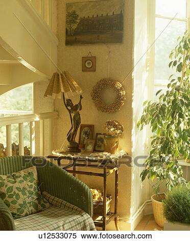 Lloyd Loom armchair beside table with Art Nouveau lamp in traditional living room View Large Photo Image Stock Photography - Lloyd Loom armchair beside table with Art Nouveau lamp in traditional living room. Fotosearch