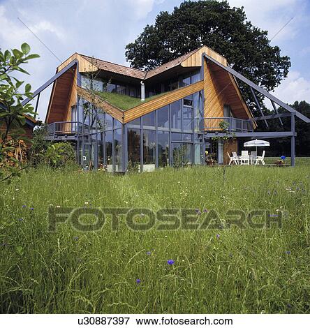Stock Photo - Long grass lawn in front of modern country house in summer. Fotosearch