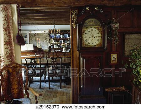 Longcase clock beside open doorway to dining room in country cottage View Large Photo Image Stock Image - Longcase clock beside open doorway to dining room in country cottage. Fotosearch