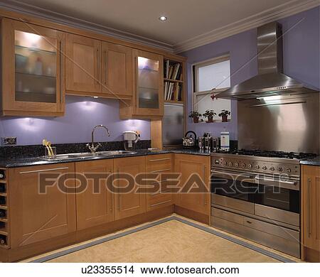 Picture - Mauve painted contemporary kitchen with wooden units and stainless steel stove. Fotosearch
