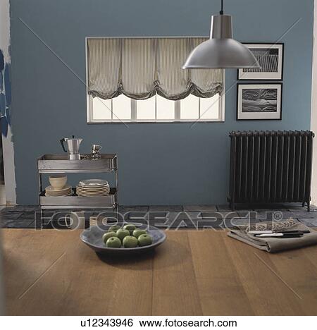 Stock Photograph - Metal light above table in blue dining room with metal trolley. Fotosearch