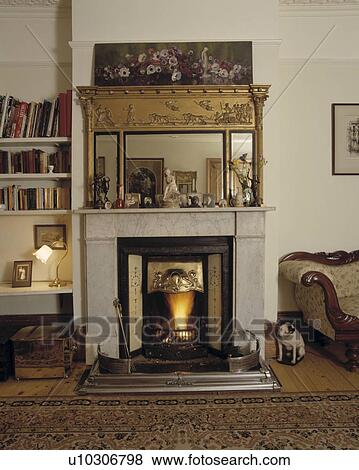 Mirror above fireplace in traditional living room View Large Photo Image Stock Photo - Mirror above fireplace in traditional living room. Fotosearch