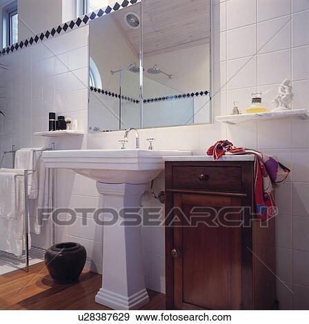 Mirror above white pedestal basin and small marble-topped antique cupboard View Large Photo Image Stock Photo - Mirror above white pedestal basin and small marble-topped antique cupboard. Fotosearch