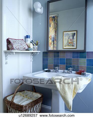 Stock Photo - Mirror and multicoloured tiles above white pedestal basin . Fotosearch