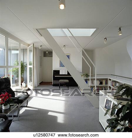 Stock Photo - Modern apartment livingroom with a piano and with a stairway leading up to rest of the house. Fotosearch