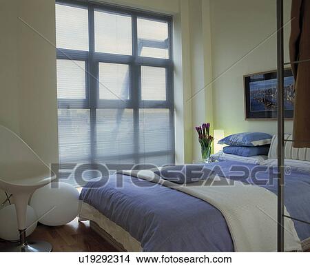 Modern blue and white bedroom with large blind covered window. View Large Photo Image Picture - Modern blue and white bedroom with large blind covered window.. Fotosearch