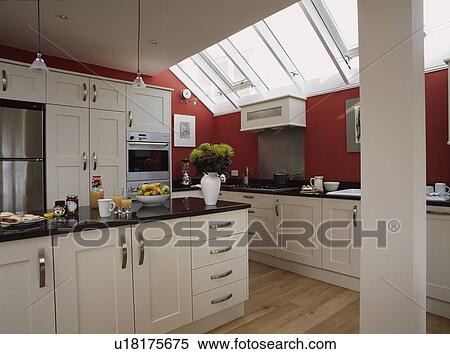 Modern kitchen extension with white fitted cupboards and red walls and half-glazed roof View Large Photo Image Stock Photography - Modern kitchen extension with white fitted cupboards and red walls and half-glazed roof. Fotosearch