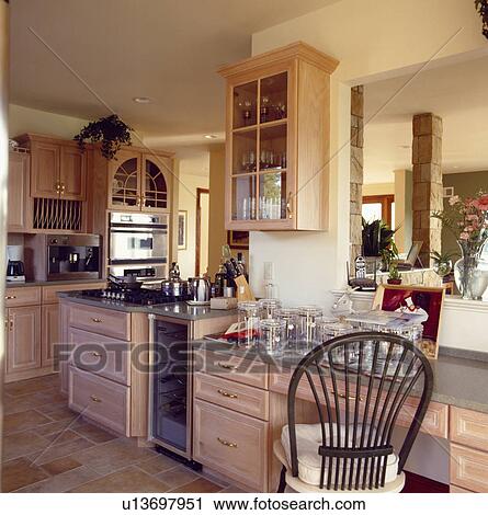 Stock Image - Modern kitchen with wine cooler built into wooden units . Fotosearch