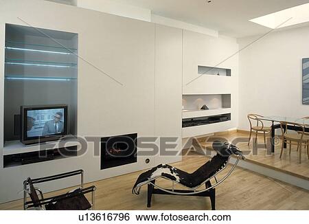 Modern living room with television on shelves and Le Corbusier chaiselongue View Large Photo Image Stock Photograph - Modern living room with television on shelves and Le Corbusier chaiselongue. Fotosearch