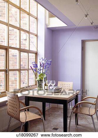 Modern plywood chairs and square table in front of large window in modern mauve dining room View Large Photo Image Stock Photo - Modern plywood chairs and square table in front of large window in modern mauve dining room. Fotosearch