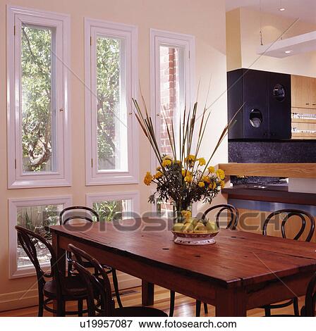 Modern primrose and white dining area with wooden table off kitchen in modern conversion. View Large Photo Image Stock Photo - Modern primrose and white dining area with wooden table off kitchen in modern conversion.. Fotosearch