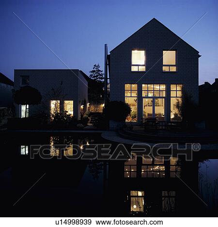 Stock Photo - Modern town house lit at night. Fotosearch