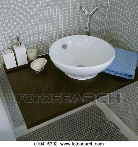 Stock Image - Modern white circular bathroom basin and freestanding chrome taps . Fotosearch