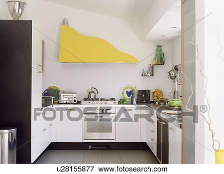 Modern white kitchen extension with extractor fan hidden behind yellow boarding View Large Photo Image Stock Photo - Modern white kitchen extension with extractor fan hidden behind yellow boarding. Fotosearch