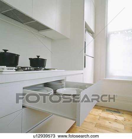 Modern white kitchen with drawer pulled out to reveal white plates View Large Photo Image Stock Image - Modern white kitchen with drawer pulled out to reveal white plates. Fotosearch