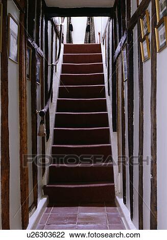 Stock Image - Narrow staircase and beamed cottage hall. Fotosearch