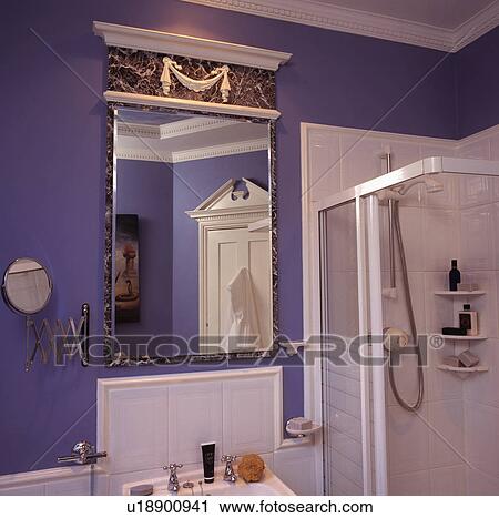 Neo-classical mirror with pediment on wall beside white tiled shower in blue bathroom View Large Photo Image Stock Image - Neo-classical mirror with pediment on wall beside white tiled shower in blue bathroom. Fotosearch