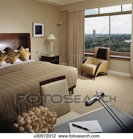 Neutral modern hotel bedroom with view of city park through window View Large Photo Image Stock Image - Neutral modern hotel bedroom with view of city park through window. Fotosearch