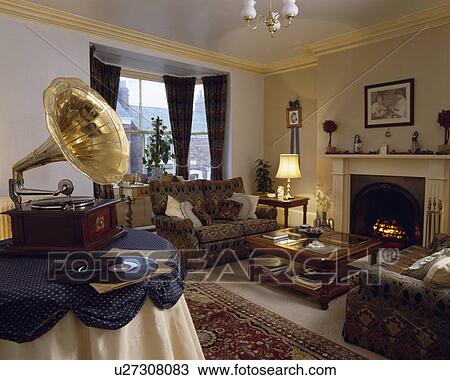 Stock Image - Old phonograph on table in traditional living room. Fotosearch