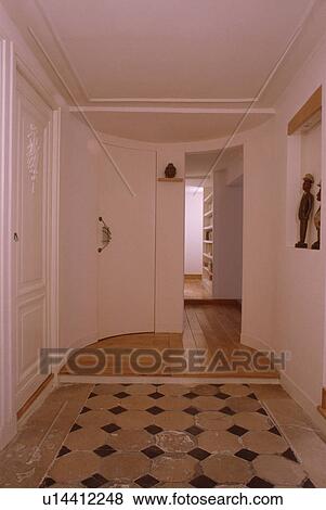 Stock Photo - Old tiled floor in small white hall with wooden flooring above step. Fotosearch