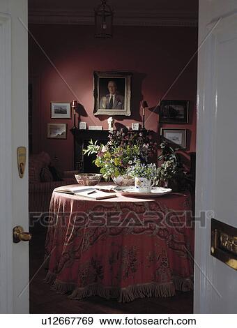 Open white doorway to red cloth on circular table in red traditional dining room View Large Photo Image Stock Photo - Open white doorway to red cloth on circular table in red traditional dining room. Fotosearch