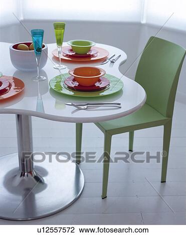 Orange and green bowls and plates on white table with metal pedestal beside green Jasper Morris 'Air' chair View Large Photo Image Stock Image - Orange and green bowls and plates on white table with metal pedestal beside green Jasper Morris 'Air' chair. Fotosearch