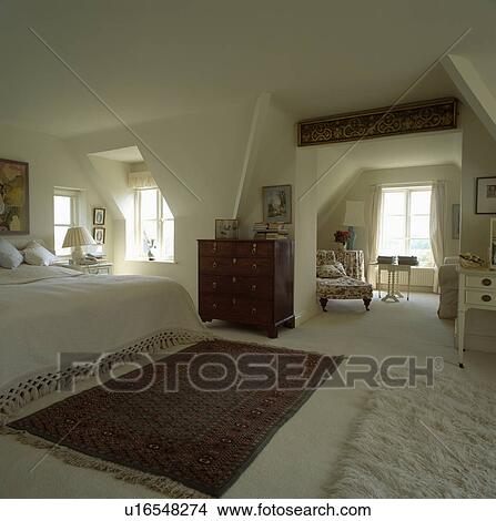 Oriental rug on cream carpet in large cream attic bedroom View Large Photo Image Picture - Oriental rug on cream carpet in large cream attic bedroom. Fotosearch