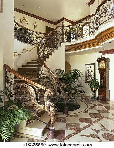 Ornate metal bannisters on stairs in hall with marble inlaid floor and longcase clock View Large Photo Image Stock Photo - Ornate metal bannisters on stairs in hall with marble inlaid floor and longcase clock. Fotosearch