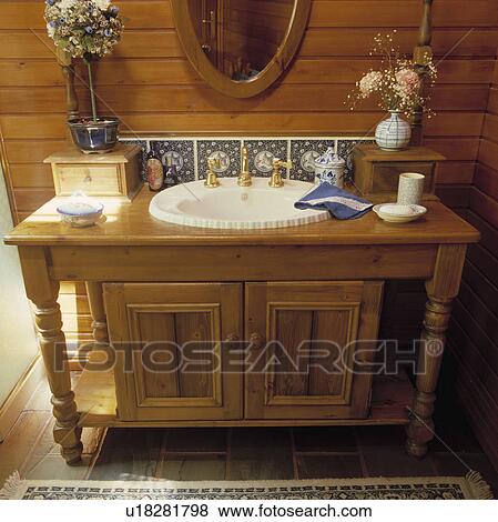 Stock Photo - Oval white basin set into pine cupboard&#13; &#10;. Fotosearch