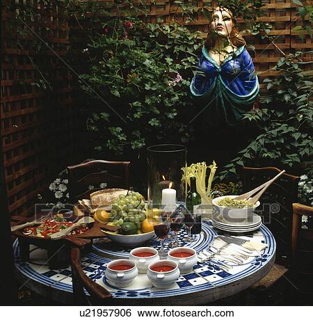 Painted statue behind table set for lunch View Large Photo Image Stock Photograph - Painted statue behind table set for lunch. Fotosearch