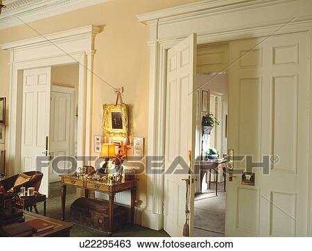 Pair of double doors on either side on lighted lamp on console table in townhouse living room View Large Photo Image Stock Image - Pair of double doors on either side on lighted lamp on console table in townhouse living room. Fotosearch