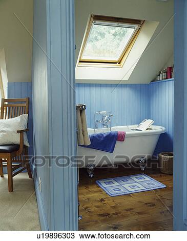 Stock Image - Pale blue attic bathroom with velux style window. Fotosearch