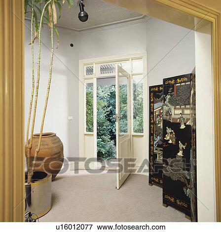 Pale grey decorated hallway with open glazed door and black oriental screen. View Large Photo Image Stock Photo - Pale grey decorated hallway with open glazed door and black oriental screen.. Fotosearch