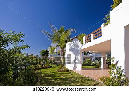 Palm trees and lawn outside modern white Spanish villa with balcony View Large Photo Image Stock Photo - Palm trees and lawn outside modern white Spanish villa with balcony. Fotosearch