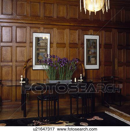 Stock Photo - Panelled dining room with blue iris in metal pot on narrow table. Fotosearch