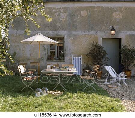 Parasol with chairs and table French garden in summer View Large Photo Image Picture - Parasol with chairs and table French garden in summer. Fotosearch