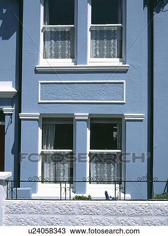 Stock Image - Pastel blue Edwardian terraced house with white paintwork. Fotosearch