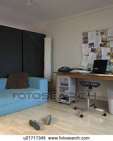 Stock Photography - Pastel blue sofa in modern living room with laptop computer and telephone on desk. Fotosearch