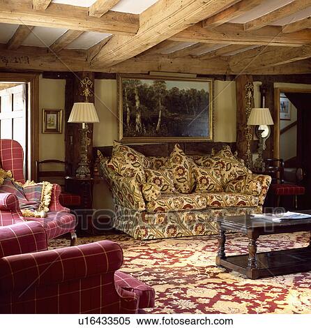 Stock Photography - Patterned carpet and sofa in beamed cottage living room. Fotosearch