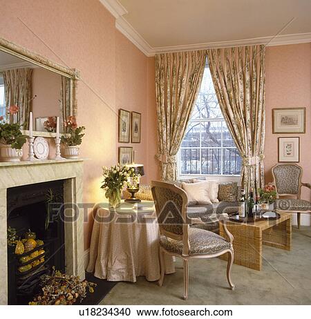 Stock Image - Patterned curtains in traditional pink living room. Fotosearch