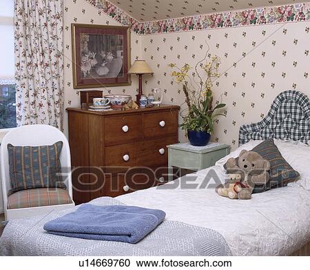 Patterned wallpaper with rose border in child's bedroom with soft toys on bed with checked upholstered headboard View Large Photo Image Stock Image - Patterned wallpaper with rose border in child's bedroom with soft toys on bed with checked upholstered headboard. Fotosearch
