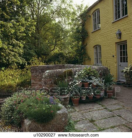Stock Photo - Paving in front of yellow country house in summer. Fotosearch